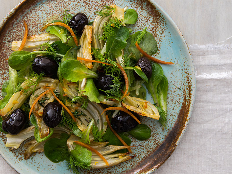 Insalata con finocchi al forno, olive nere tostate e scorzette di arancia essiccata